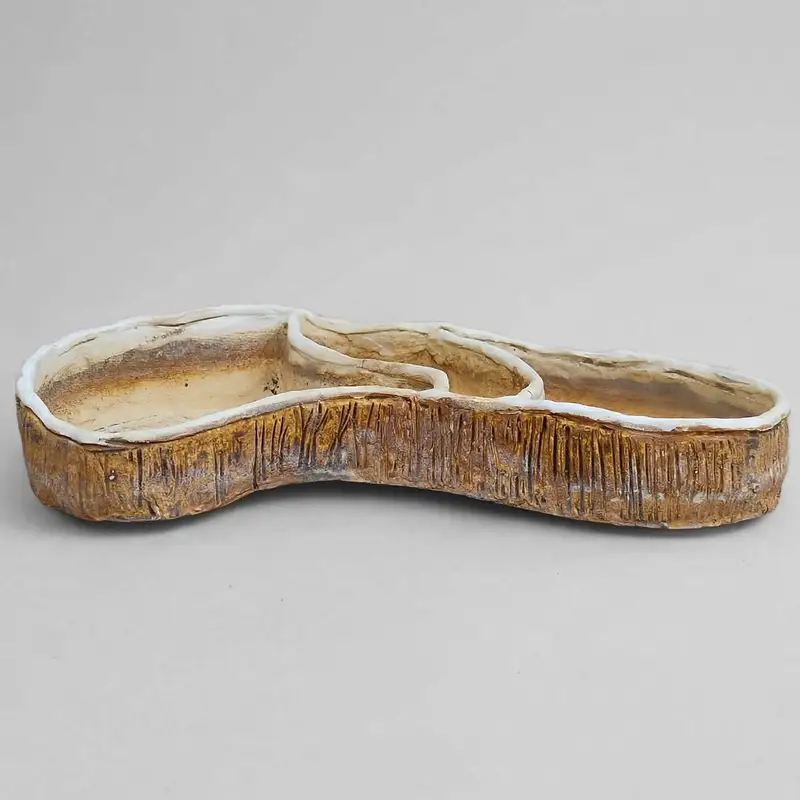 Cream three-lobed ceramic tray with a brown textured exterior